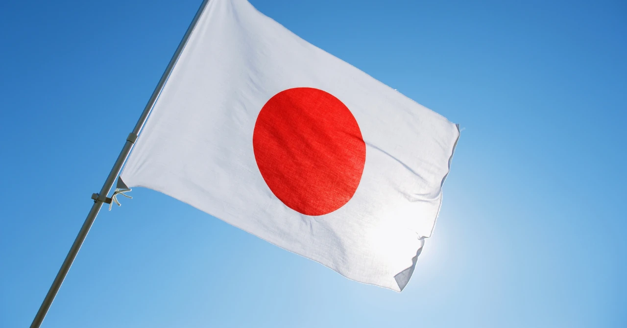 青空を背景にはためく日本の国旗。個人向け国債への「やめとけ」という批判を検証する記事のヘッダー画像